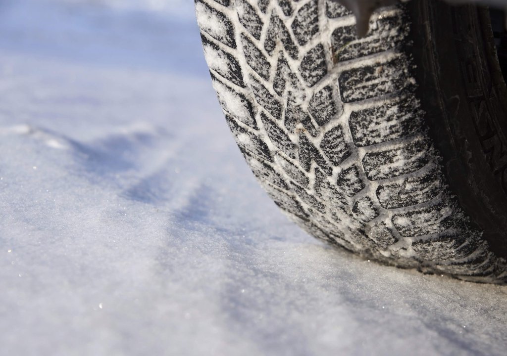 A winter tyre on a snowy road.