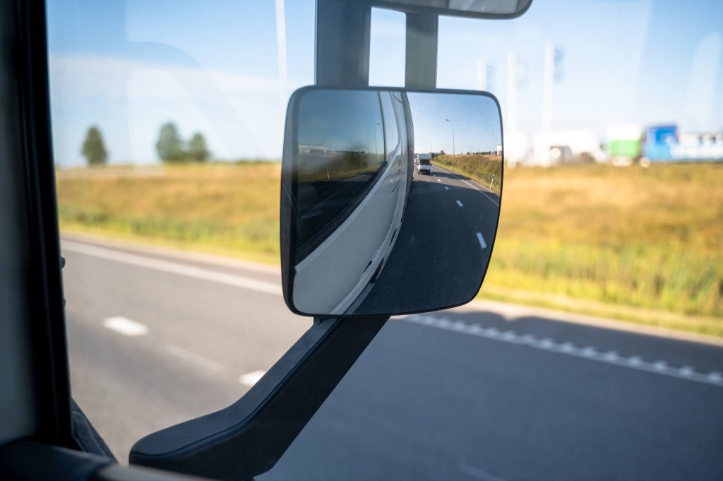 A lorry wing mirror with the road beyond.