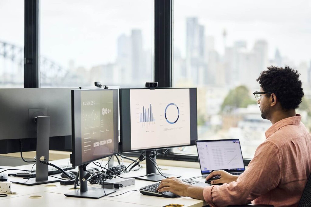 Analyst reviewing fleet data on several monitors.