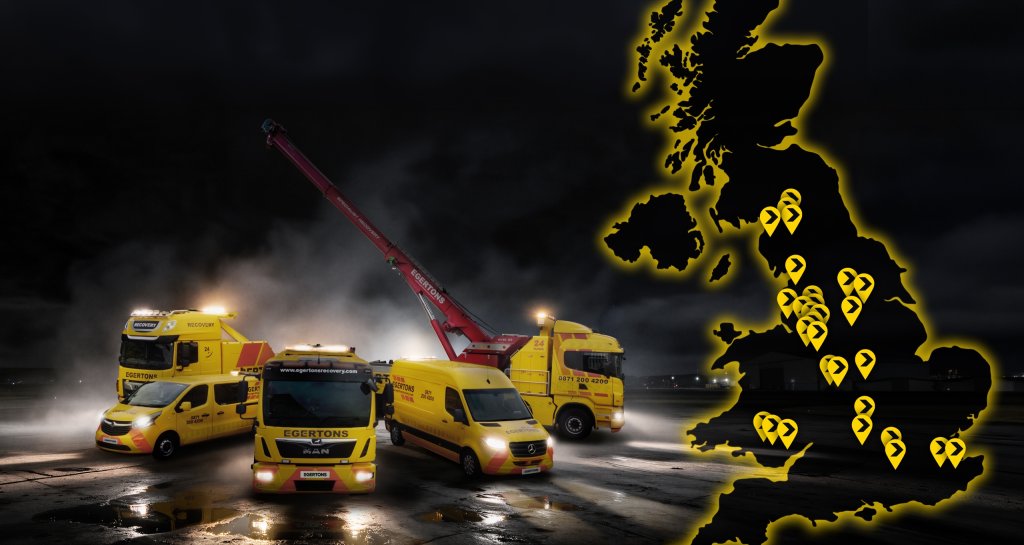 Egertons yellow recovery trucks and vans parked at night with lights on, beside a glowing map of the UK marking Egertons depots.