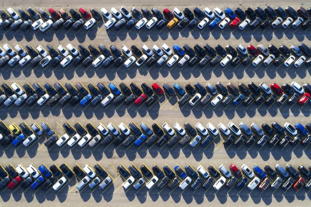 Aerial view of rows of vehicles parked in a secure storage compound.